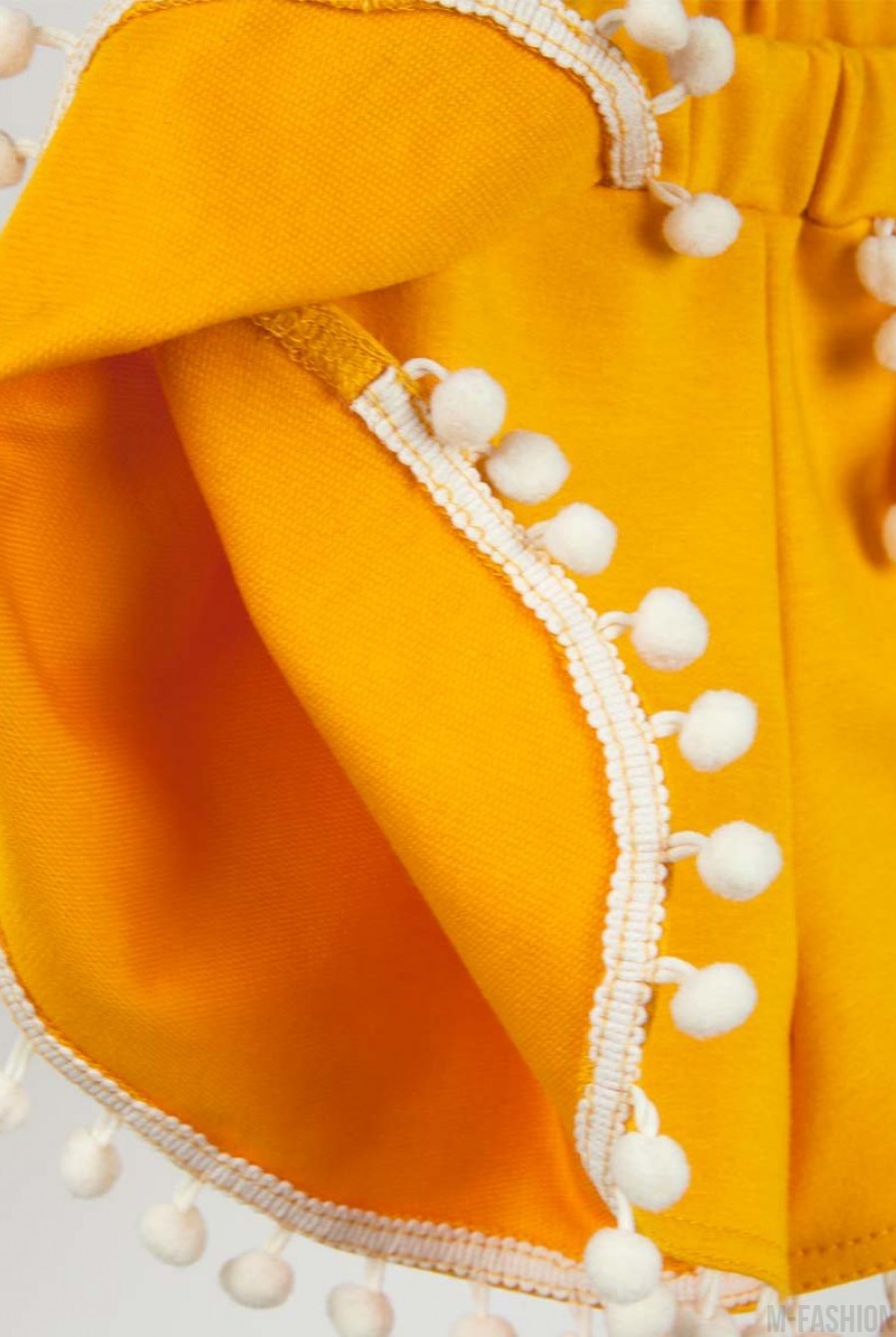 Горчичные шорты из футера с декором из маленьких белых помпонов- Фото 6