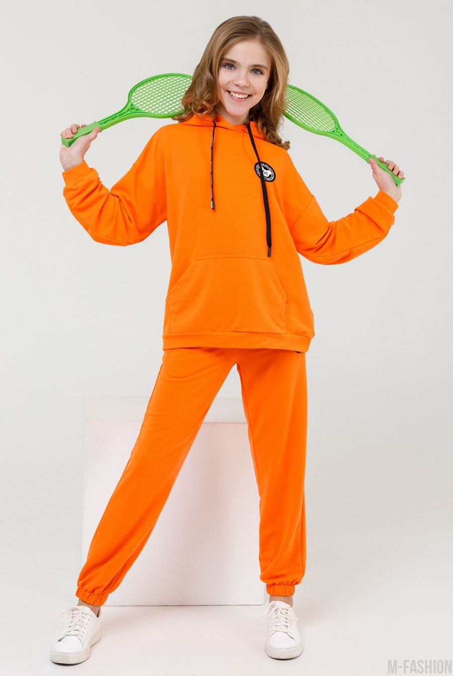 Оранжевый трикотажный костюм с нашивкой - Фото 1