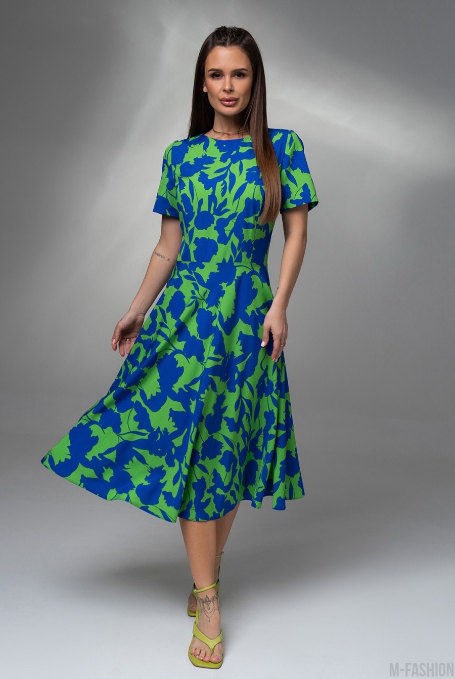 Зеленое приталенное платье с синим принтом  - Фото 1