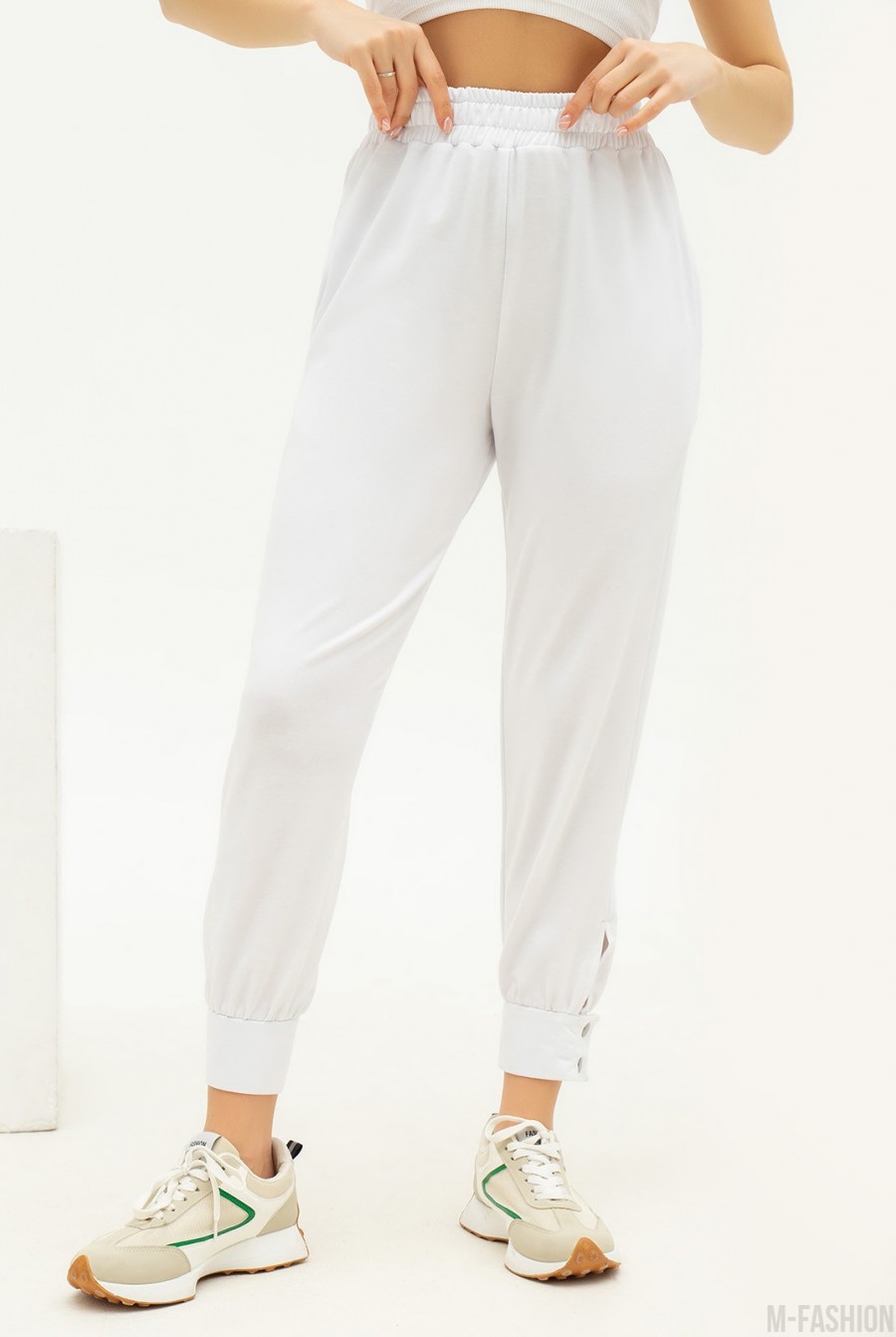 Белые трикотажные брюки с декоративными манжетами  - Фото 1